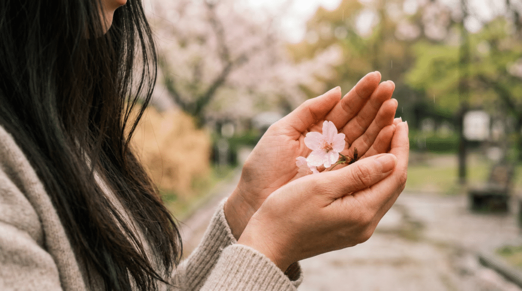 Frau hält eine Blume in den Händen